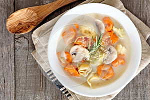 Creamy tortellini and mushroom soup, above scene on rustic wood