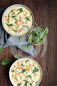 Creamy Tortellini pasta soup with spinach, celery, carrot and chicken broth