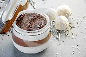 Creamy Vanilla and Chocolate Mousse Dessert in Jar with Coconut Balls On a Gray Background. Concept Valentine`s Day