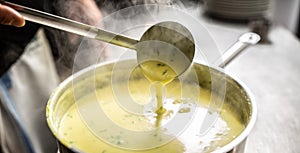 Creamy vegetable mixed soup steaming as ladle stirs it in a pot