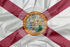Crease of Florida flag background. A red saltire on a white background, with the state seal superimposed on the center