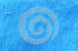 Creased blue cloth material fragment as a background textur