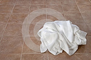 Creased white towels on ceramic floor photo