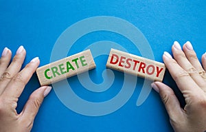 Create or Destroy symbol. Concept word Create or Destroy on wooden blocks. Businessman hand. Beautiful blue background. Business