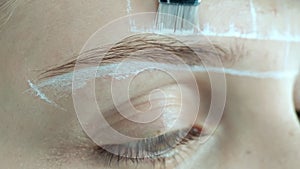 Create permanent eyebrow makeup. Marking the shape of the eyebrows.