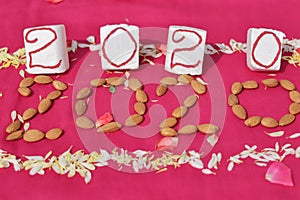 Create 2020 with almonds and flowers on pink background