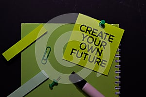 Create Your Own Future write on Sticky Notes. Top view isolated on black background