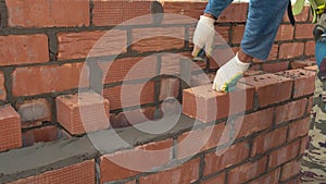 Creating brickwork - a fragment of the wall of a multi - storey building. Professional construction activity. Manual