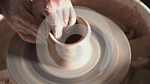 Creating earthenware and traditional pottery concept. Experienced male potter`s hands creating beautiful clay product -