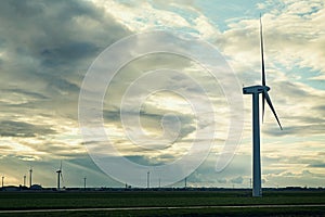 Creating energy without harming the planet. a cluster of wind turbines standing in an open field.