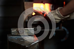 Creating iron tools in blacksmith`s on the old plank wood table