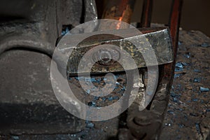 Creating iron tools in blacksmith`s on the old plank wood table