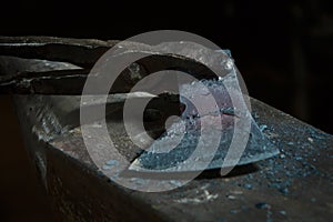 Creating iron tools in blacksmith`s on the old plank wood table