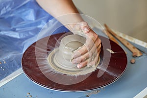 Creating jar or vase of clay. Woman hands, potter`s wheel photo