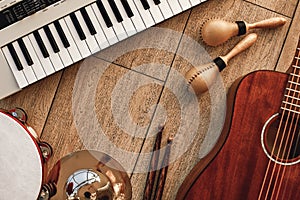 Creating a melody...Top view of musical instruments set: synthesizer, electronic guitar, wooden drum sticks, golden