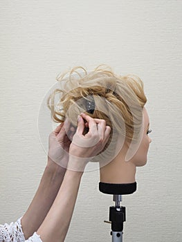 Creation of a hairstyle on a mannequin.