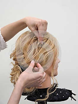 Creation of a hairstyle on a mannequin.