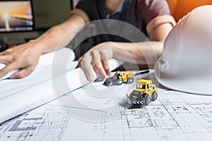 Creative architect projecting on the big drawings in the dark lo