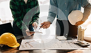 Creative architect projecting on the big drawings in the dark loft office or cafe in sun light