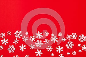 Creative arrangement of christmas decoration snowflakes on red background. Holiday concept. Flat lay, top view