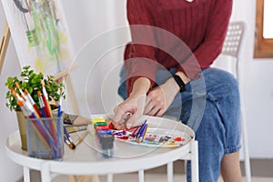 Creative of art concept, Young asian woman choose paintbrush for work to drawing artwork in studio
