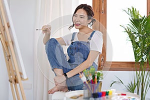 Creative of art concept, Young asian woman hold paintbrush and canvas to prepare for drawing