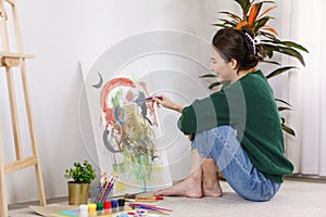 Creative of art concept, Young asian woman sitting on the floor to painting artwork in art studio