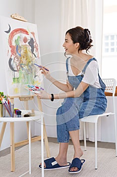 Creative of art concept, Young asian woman using paintbrush with color palette to drawing artwork