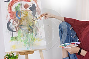 Creative of art concept, Young asian woman using paintbrush with color palette to drawing on canvas