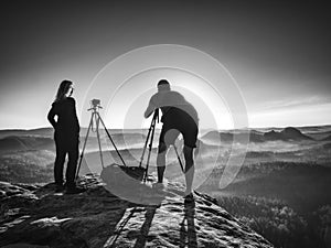 Creative artists stay at own cameras on tripods.  Hikers and enthusiasts photo