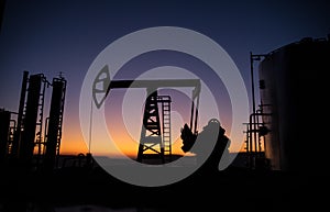 Creative artwork decoration. Oil pump and oil refining factory at sunset. Energy industrial concept. Selective focus