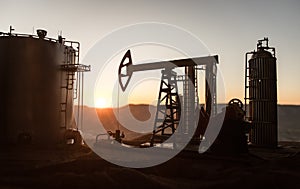 Creative artwork decoration. Oil pump and oil refining factory at sunset. Energy industrial concept. Selective focus