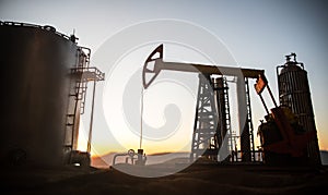 Creative artwork decoration. Oil pump and oil refining factory at sunset. Energy industrial concept. Selective focus