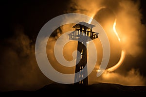 Creative artwork decoration. Silhouette of army watchtower at night. Selective focus