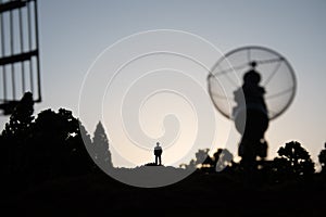 Creative artwork decoration. Silhouette of mobile air defence truck with radar antenna during sunset. Satellite dishes or radio