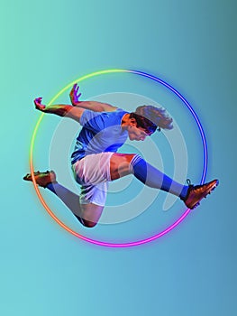 Creative artwork of prfessional male football player in motion over neon geometric element  over blue background