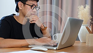 Creative asian man working with computer laptop at modern workplace