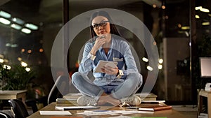 Creative Asian woman sitting on office table, thinking startup ideas, writer