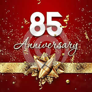 Creative background, 85 years old. Celebration of golden text and confetti on a red background with numbers and golden bow.