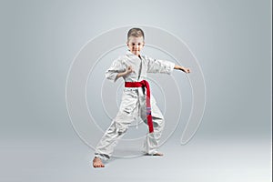 Creative background, baby in white kimono on a light background. The concept of martial arts, karate, sports since