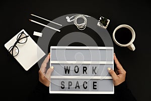 Creative black desktop laptop, coffee, glasses, headphones, pencils, workspace words.