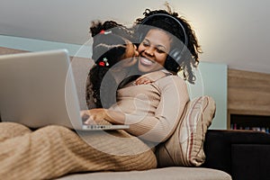 Creative black mother and daughter working on school project, using modern laptop