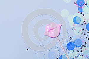 Creative blue confetti background with pink lips. Top view