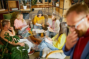 Creative brainstorming. Group of employees, men and women, having meeting, discussion at the office, indoors. Concept of