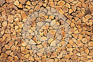 Creative brown background of neatly stacked firewood. Brown texture of natural wood.