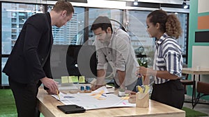 Creative business people group having conversation at office desk in workplace.