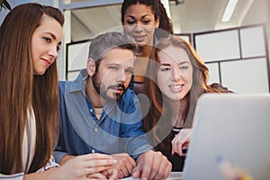 Creative business people using laptop at desk