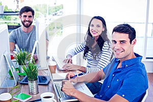 Creative business people using laptop in meeting