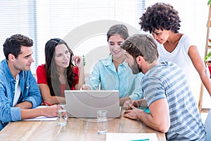 Creative business people using laptop in meeting