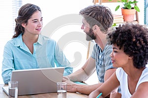 Creative business people using laptop in meeting